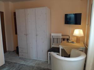 a room with a cabinet and a table with a lamp at Hotel Irene in Bad König
