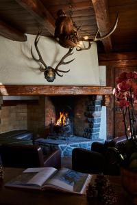 a living room with a fireplace and a table with a book at Hotel Europa in Cortina dʼAmpezzo