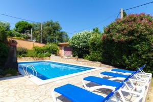 een zwembad met twee blauwe stoelen naast een huis bij Club Villamar - Jordan in Lloret de Mar
