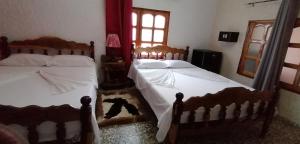 a bedroom with two beds and a bear on the floor at El Campesino Yuri y Nino in Viñales