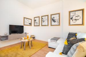 uma sala de estar com um sofá branco e uma mesa em WHome | Anjos Stylish Apartment #10 em Lisboa
