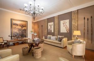 a living room with a chandelier and a couch and chairs at Karongwe Portfolio- Shiduli Private Game Lodge in Karongwe Game Reserve