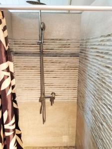een douche met een douchegordijn in de badkamer bij Coco room in Blue Bay