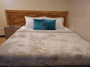 un grande letto con due cuscini blu sopra di Alona Vikings Lodge 1 a Panglao