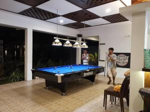 two men playing a game of pool in a house at Alona Vikings Lodge 1 in Panglao