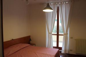 um quarto com uma cama e uma grande janela em La Torre em Marciana Marina