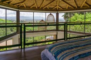 a bedroom with a bed and a balcony with a view at Cannua Lodge in Marinilla