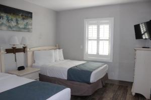 Habitación de hotel con 2 camas y ventana en Shoreline Suites & Cabana Cottages – Beachfront, en Daytona Beach