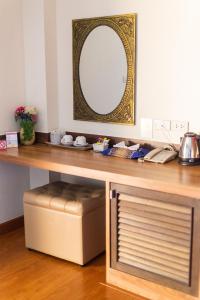 una mesa con un espejo y un taburete debajo en Palm Coco Mantra, en Lamai