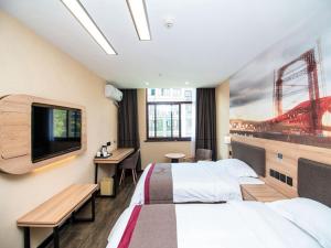 a hotel room with two beds and a flat screen tv at Thank Inn Plus Hotel Jiangsu Suqian Diamond Apartment in Suqian