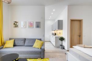 ein Wohnzimmer mit einem grauen Sofa und gelben Kissen in der Unterkunft Rózsa Apartments in Budapest