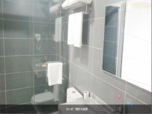 a bathroom with a sink and a mirror and a toilet at Thank Inn Chain Hotel Shanghai jinshan, jinshan new town in Nanhui