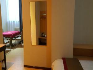 a room with a bed and a mirror on a wall at Thank Inn Chain Hotel Shanxi xianyang train station in Xianyang
