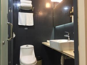 uma casa de banho com um WC branco e um lavatório. em Thank Inn Chain Hotel Jiangsu Suzhou Taihu Lake Dongshan Town em Suzhou