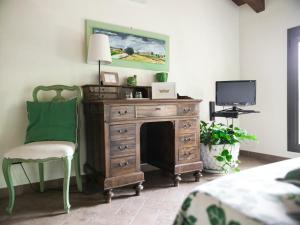 Zimmer mit einer Holzkommode, einem Stuhl und einem TV in der Unterkunft Quattrocolli B&B in Quattro Castella