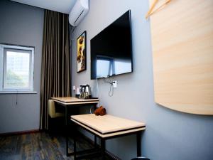 a room with two desks and a tv on a wall at Thank Inn Chain Hotel henan luoyang high-tech district jiudu west road zhoushan station in Luoyang