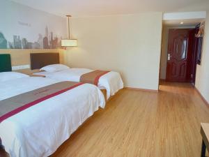 um quarto de hotel com duas camas e um piso de madeira em Thank Inn Chain Hotel tibet shigatse angren county government em Kaika