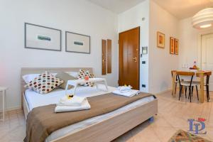 デセンツァーノ・デル・ガルダにあるDesenzanoLoft Porto Vecchioのベッドルーム1室(ベッド1台、タオル2枚付)