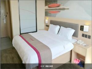 a bedroom with a large white bed and a window at Thank Inn Chain Hotel Shanghai jinshan, jinshan new town in Nanhui
