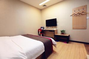 a bedroom with a bed and a desk with a television at Thank Inn Chain Hotel shanxi weinan linwei district jiefang road in Weinan