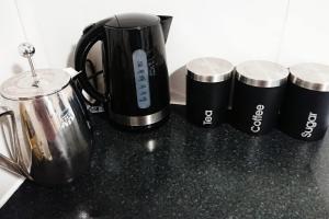 a group of three cups on a counter next to a blender at J BOOK NOW, Spacious 5 Bed Sleeps 9 Long Stays Workers & Families by Your Night Inn Group in Wolverhampton
