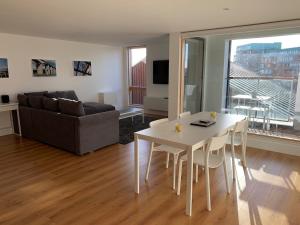 a living room with a table and a couch at Toothbrush Apartments - Ipswich Waterfront - Quayside in Ipswich