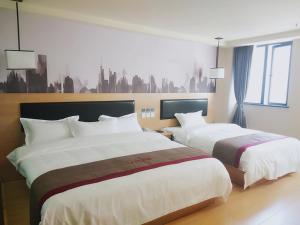 a hotel room with two beds and a window at Thank Inn Chain Hotel Chongqing nanan district tongjing international store in Chongqing