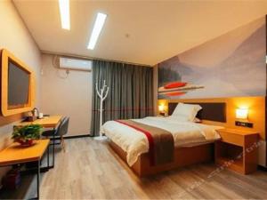 una camera d'albergo con letto e scrivania di Thank Inn Chain Hotel henan zhengzhou future road convention and exhibition center a Zhengzhou