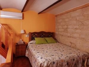 una camera con letto e parete in pietra di Pensión Antonio Guesthouse ad Alicante
