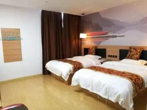 een hotelkamer met drie bedden en een schilderij aan de muur bij Thank Inn Chain Hotel Jiangsu suzhou kunshan foxconn in Suzhou