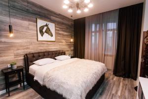 a bedroom with a bed and a wooden wall at Apartments on Malygina in Tyumen