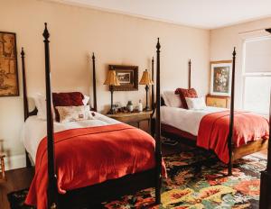 um quarto com 2 camas com edredão vermelho em The Mabelle em Pawhuska