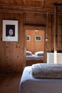 two beds in a room with wooden walls at AgroPobitzer in Malles Venosta