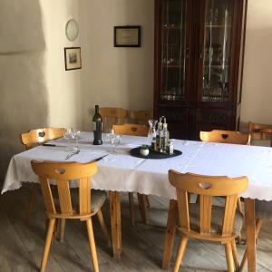 a dining room table with a white table cloth and chairs at AgroPobitzer in Malles Venosta