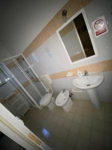 a bathroom with a sink and a toilet and a mirror at Stella Marina Albergo Diffuso - B&B in Noto Marina