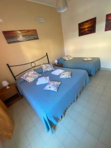 2 camas con sábanas azules en una habitación en Stella Marina Albergo Diffuso - B&B, en Marina di Noto