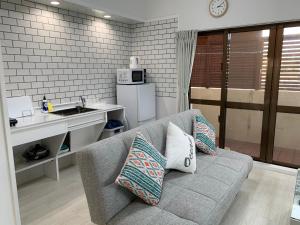 a living room with a couch and a kitchen at Maximum of 18 people can be rented in one building 3 minutes walk to Tomari Port 10 minutes drive to the airport No parking lot 30 seconds walk from paid parking lot warayunso port city May in Naha