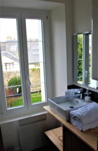 a bathroom with a sink and two windows at Cosy Street Studio in Pontivy