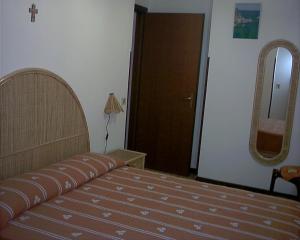 a bedroom with a bed and a mirror at Casa Vacanze Capo Vaticano in Ricadi