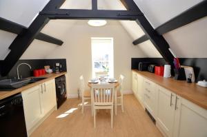 a kitchen with a table and chairs in a room at George & Dragon in Dartmouth