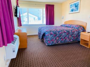 a hotel room with a bed and a window at A 1 A Super Inn in Ormond Beach
