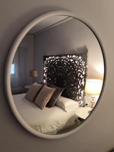 espejo que refleja una cama en un dormitorio en La Parada de Echegaray, en Zaragoza