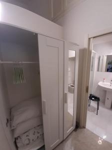 um quarto branco com uma cama e um espelho em Borgoanticoview em Bari