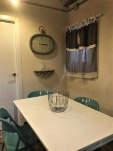 einen weißen Tisch mit Stühlen und eine Uhr an der Wand in der Unterkunft Tetuan Silence in Valencia