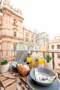 - une table avec des assiettes de nourriture et des verres de vin dans l'établissement Malaga Center Flat Cathedral, à Malaga