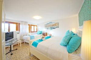 een slaapkamer met een bed met blauwe kussens en een televisie bij Campo San Polo Apartment Rialto in Venetië +36 foto's