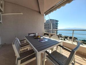 una mesa y sillas en un balcón con vistas al océano en Ionian Sea View Apartment, en Sarandë