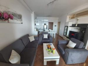 sala de estar con sofá y mesa en Ionian Sea View Apartment, en Sarandë