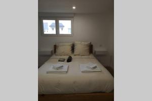 um quarto com uma cama com toalhas e uma janela em Le Bigorneau em Langueux