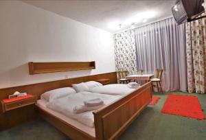 a bedroom with a large bed and a table at Hotel Vanda in Irschen